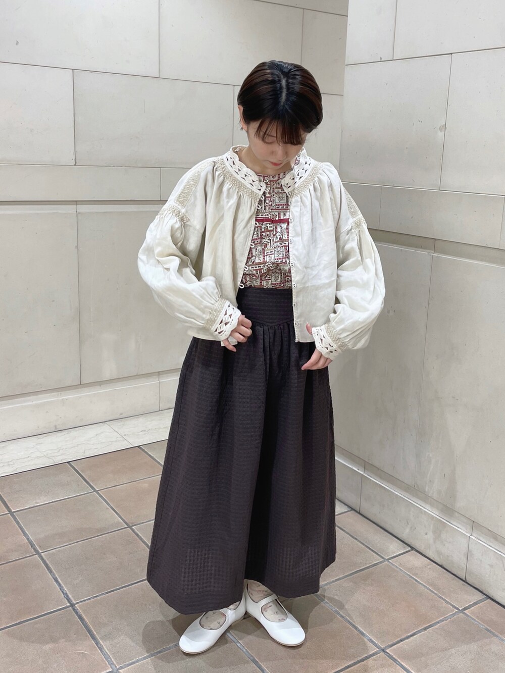 レッド系のシャツ/ブラウス、ホワイト系のシャツ/ブラウス、グレー系のスカートを着用したレディースの冬コーディネートの2枚目の写真