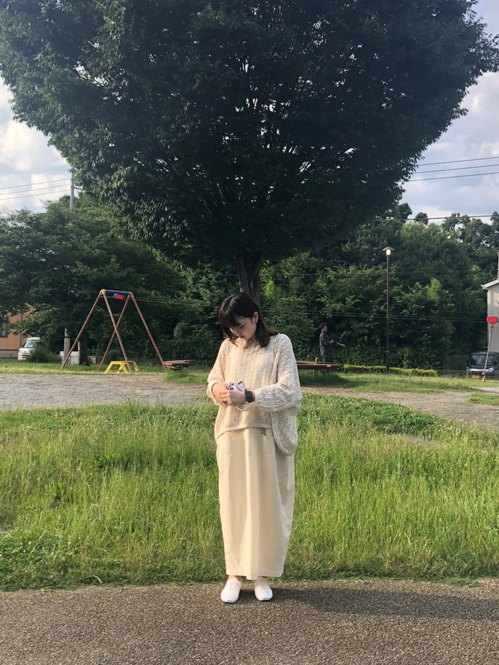 ベージュ系のトップス、ホワイト系のワンピースを着用したレディースの夏コーディネートの2枚目の写真