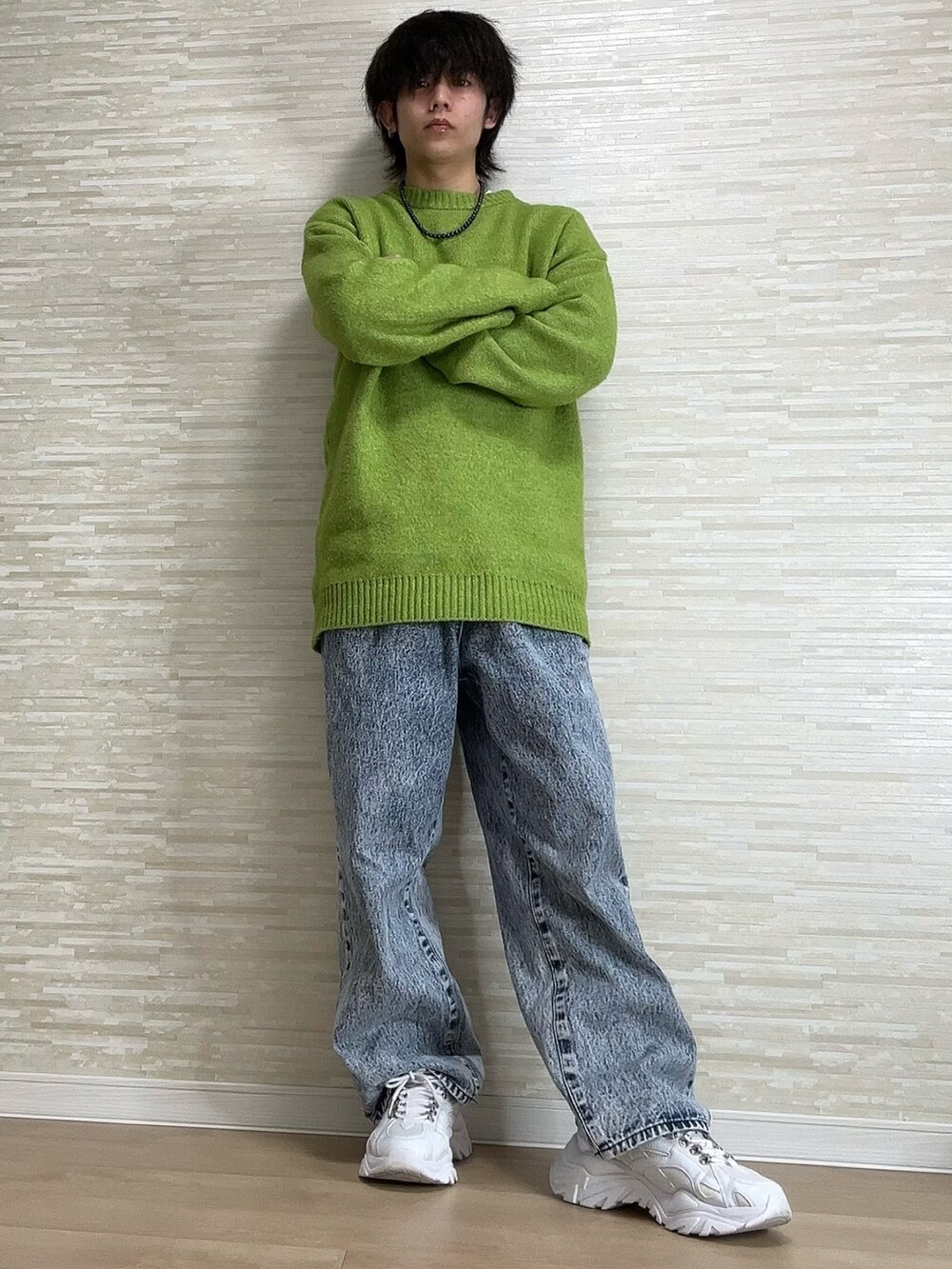 グリーン系のニット/セーター、ブルー系のデニムパンツ、ホワイト系のスニーカーを着用したメンズの冬コーディネートの2枚目の写真