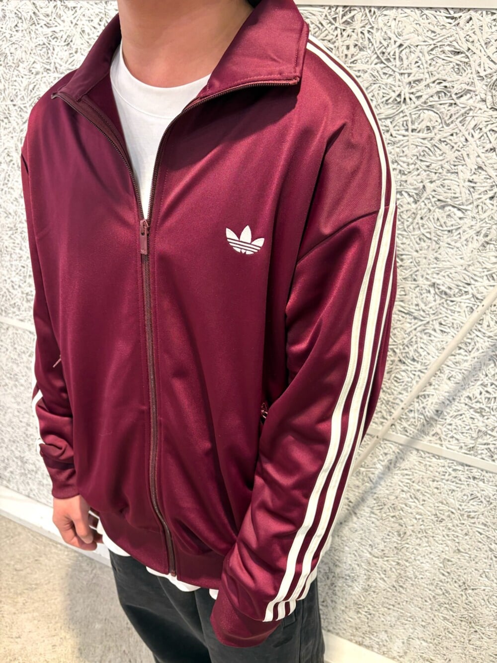 レッド系のジャージ、ブラック系のその他パンツ、ゴールド系のシューズを着用したメンズの春コーディネートの2枚目の写真