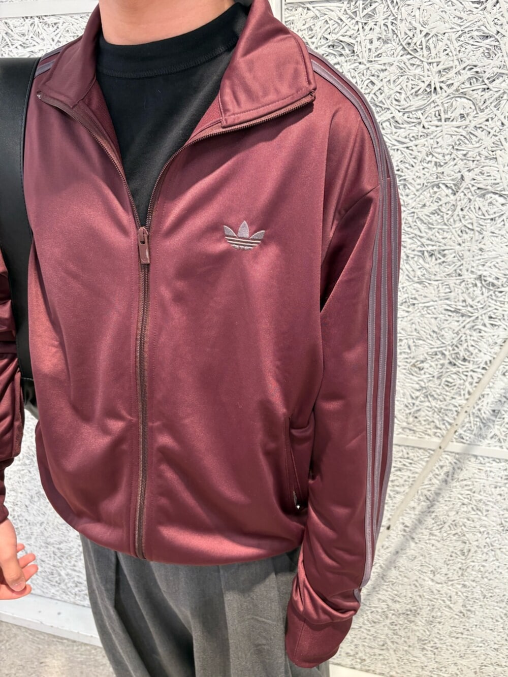 レッド系のジャージ、レッド系のスニーカー、ブラック系のショルダーバッグを着用したメンズの春コーディネートの2枚目の写真