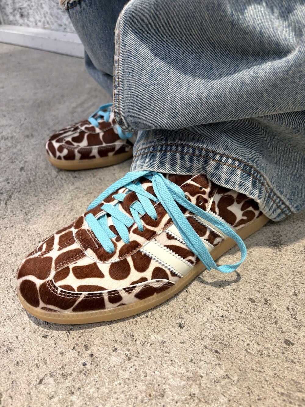 ブラウン系のブルゾン、ブルー系のデニムパンツ、ベージュ系のスニーカーを着用したメンズの春コーディネートの4枚目の写真