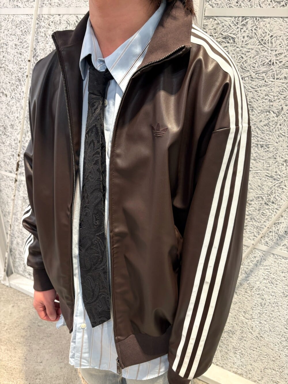 ブラウン系のブルゾン、ブルー系のデニムパンツ、ベージュ系のスニーカーを着用したメンズの春コーディネートの2枚目の写真