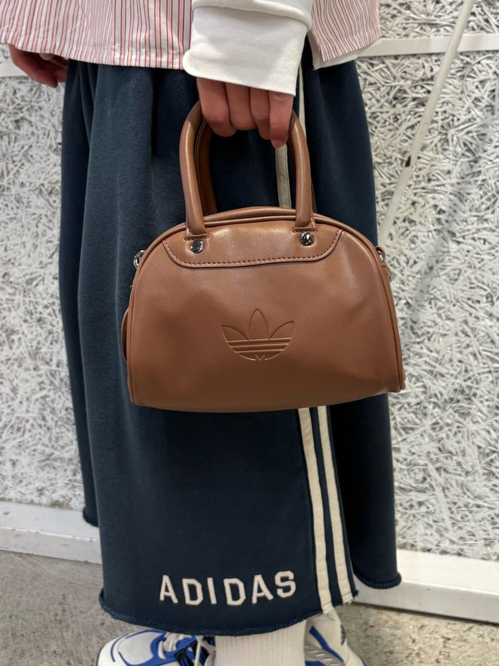 ブルー系のスウェットパンツ、ブルー系のスニーカー、ブラウン系のハンドバッグを着用したメンズの夏コーディネートの3枚目の写真