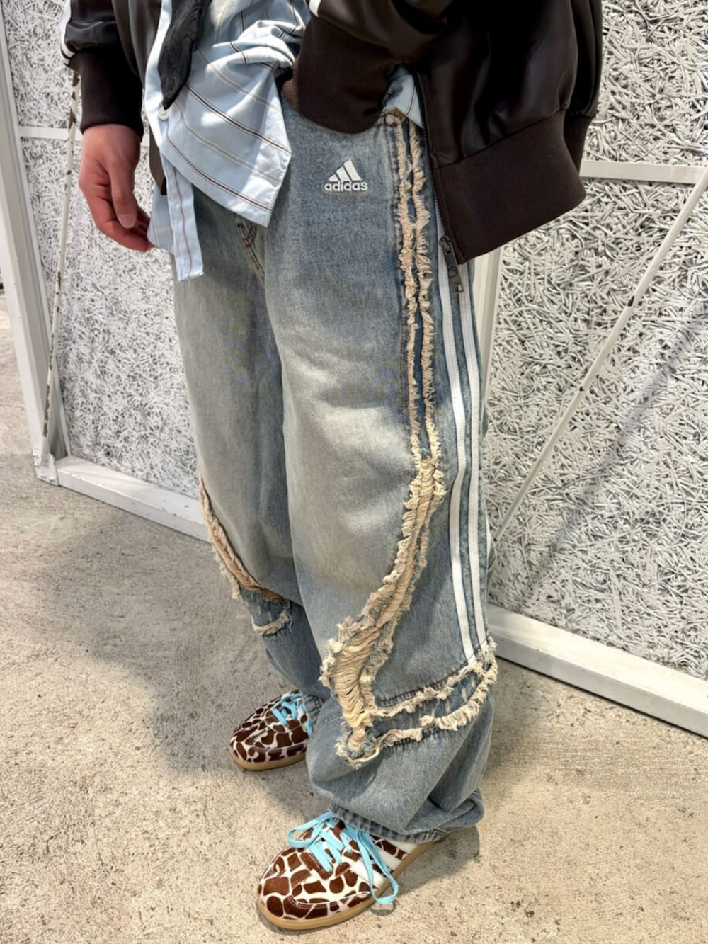 ブラウン系のブルゾン、ブルー系のデニムパンツ、ベージュ系のスニーカーを着用したメンズの春コーディネートの3枚目の写真