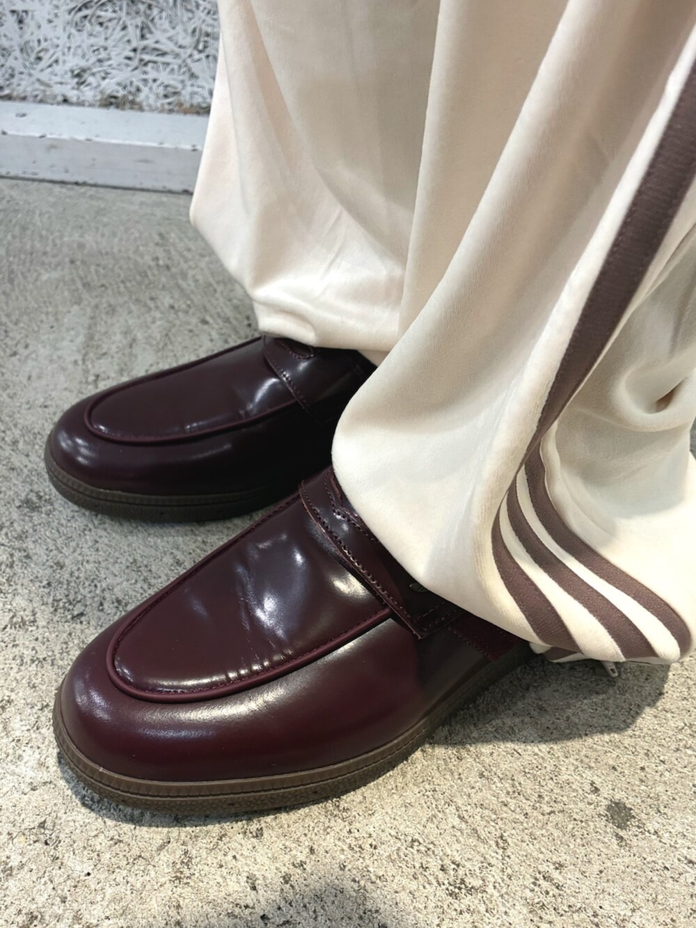 ホワイト系のジャージ、ホワイト系のパンツ、レッド系のローファーを着用したメンズの秋コーディネートの4枚目の写真