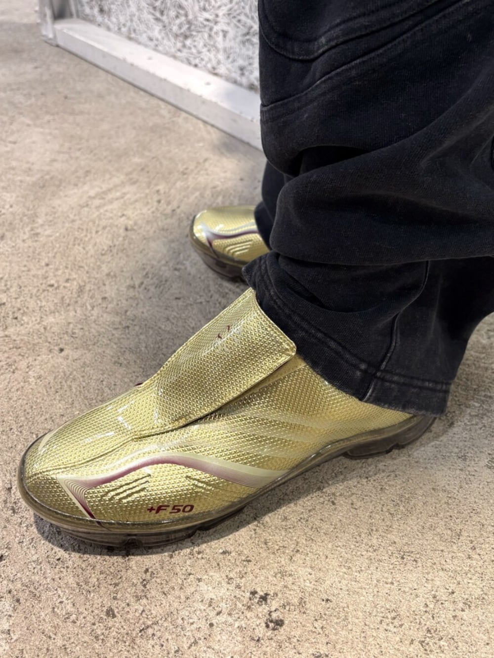 レッド系のジャージ、ブラック系のその他パンツ、ゴールド系のシューズを着用したメンズの春コーディネートの4枚目の写真