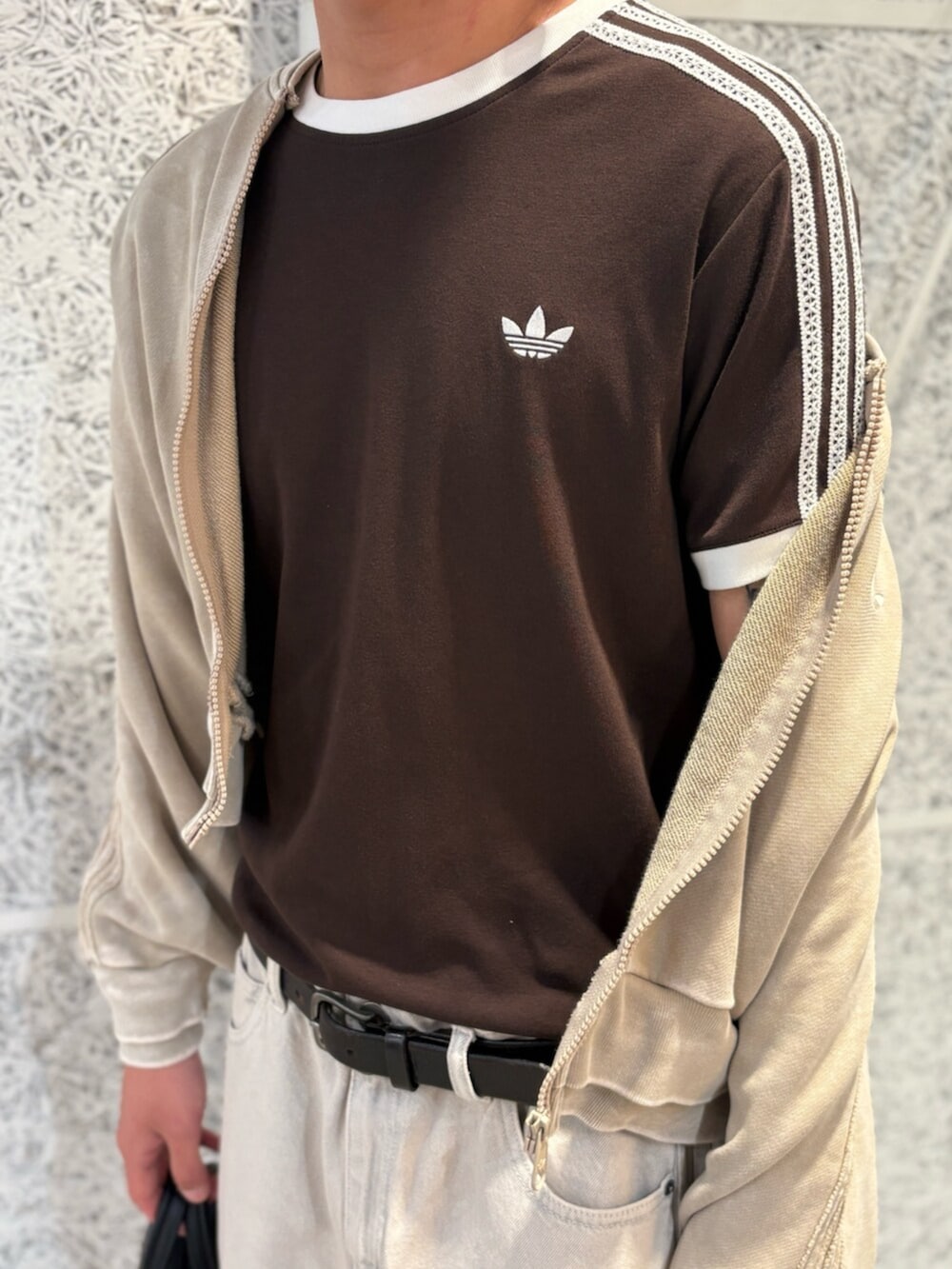 ベージュ系のジャージ、ブラック系のショルダーバッグ、ブラウン系のTシャツ/カットソーを着用したメンズの夏コーディネートの4枚目の写真