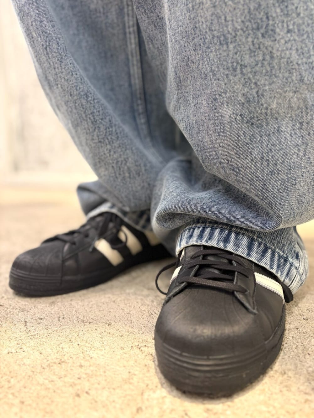 ブラック系のジャージ、ブルー系のデニムパンツ、ブラック系のスニーカーを着用したメンズの秋コーディネートの4枚目の写真