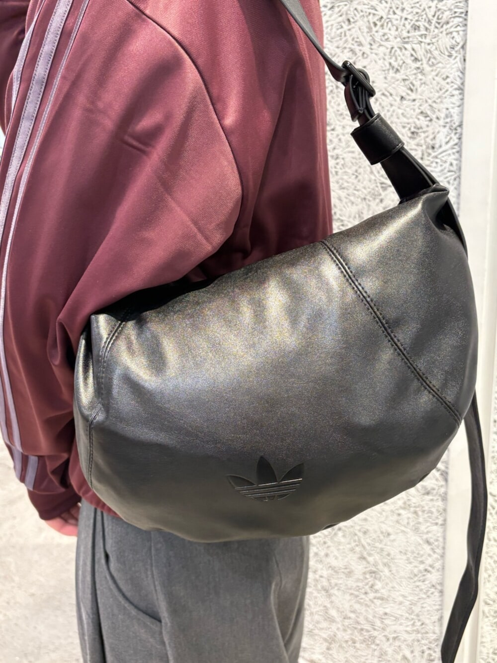 レッド系のジャージ、レッド系のスニーカー、ブラック系のショルダーバッグを着用したメンズの春コーディネートの3枚目の写真