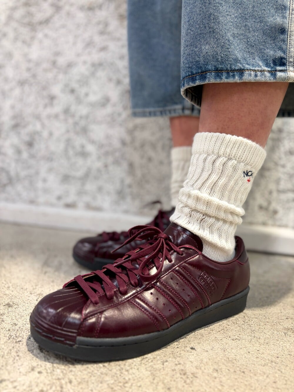 ブルー系のデニムパンツ、レッド系のシューズを着用したメンズの夏コーディネートの4枚目の写真