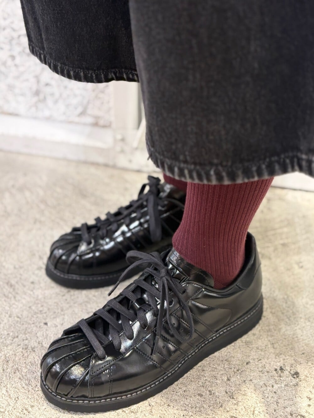 ブラック系のスニーカー、ブラック系のデニムパンツを着用したメンズの夏コーディネートの4枚目の写真