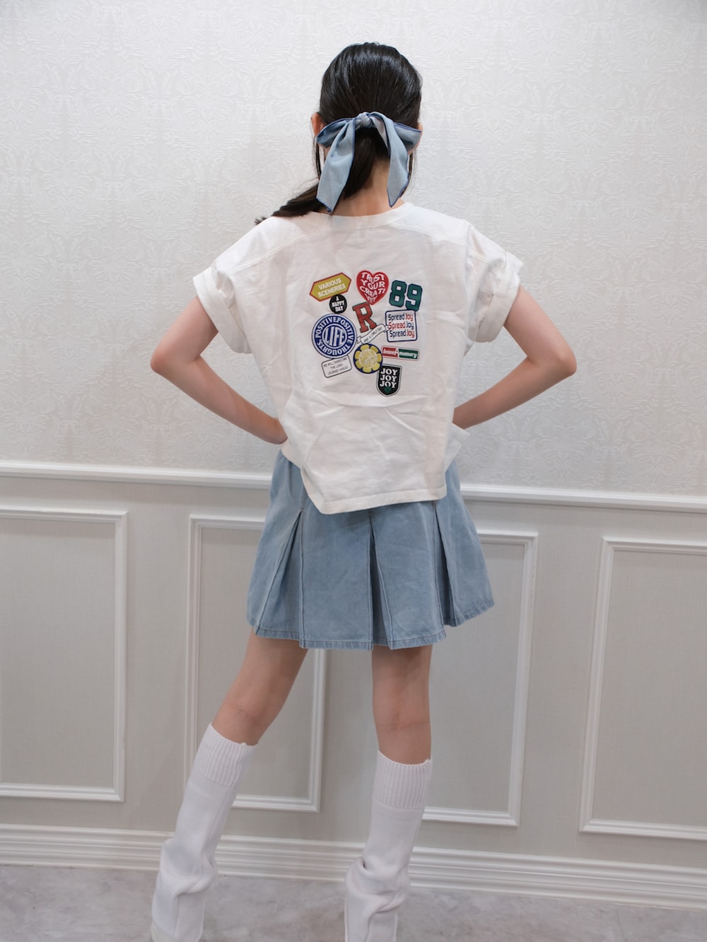 ブルー系のデニムスカート、ホワイト系のTシャツ/カットソー、ホワイト系のレッグウォーマーを着用したレディースの夏コーディネートの2枚目の写真