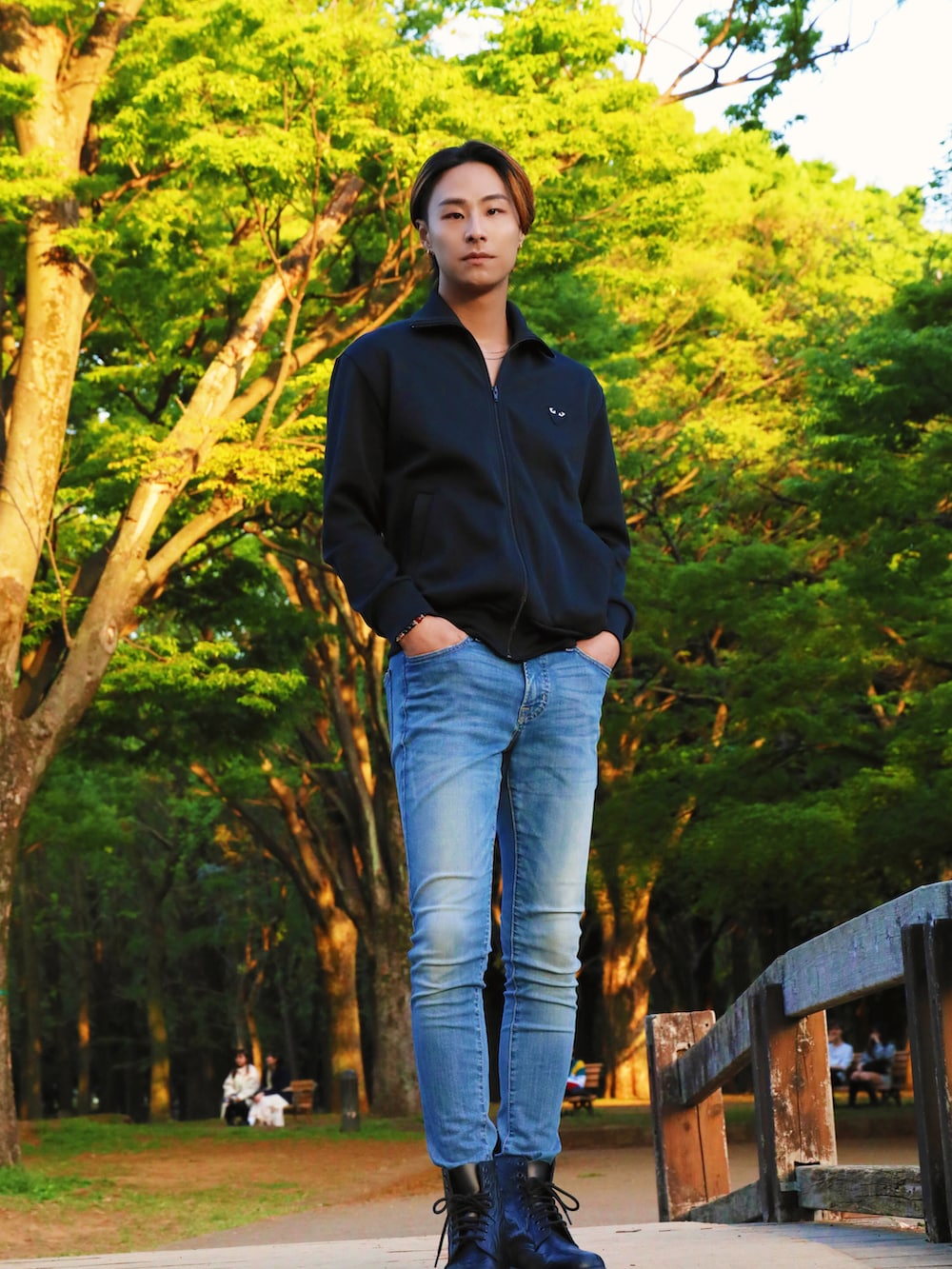 ブラック系のジャージ、ブルー系のデニムパンツ、ブラック系のブーツを着用したメンズの春コーディネートの2枚目の写真