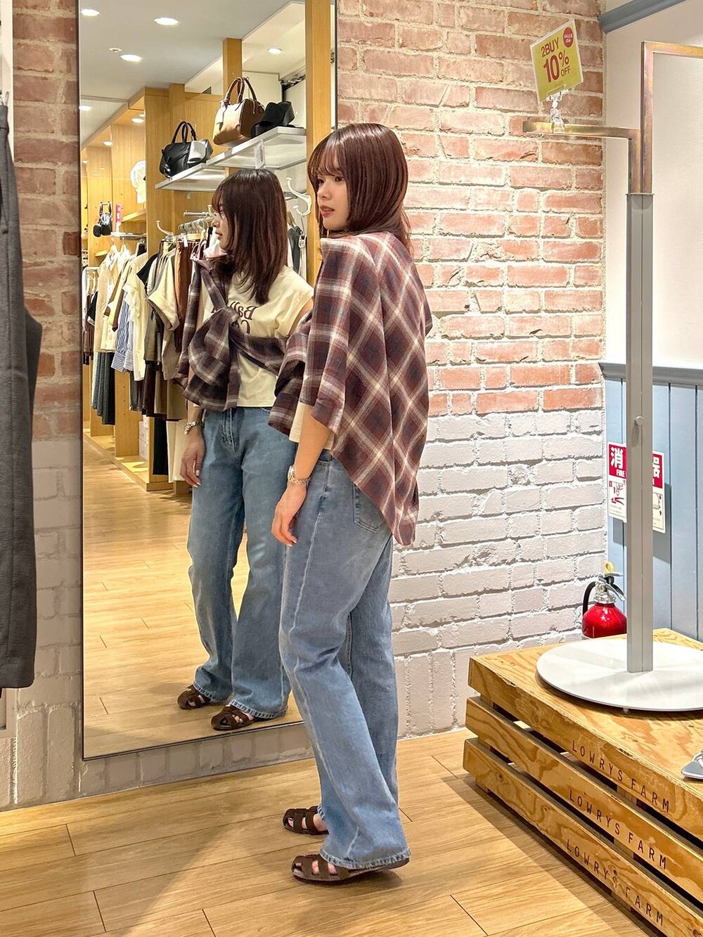 ブラウン系のサンダル、ブルー系のデニムパンツ、レッド系のシャツ/ブラウスを着用したレディースの夏コーディネートの2枚目の写真