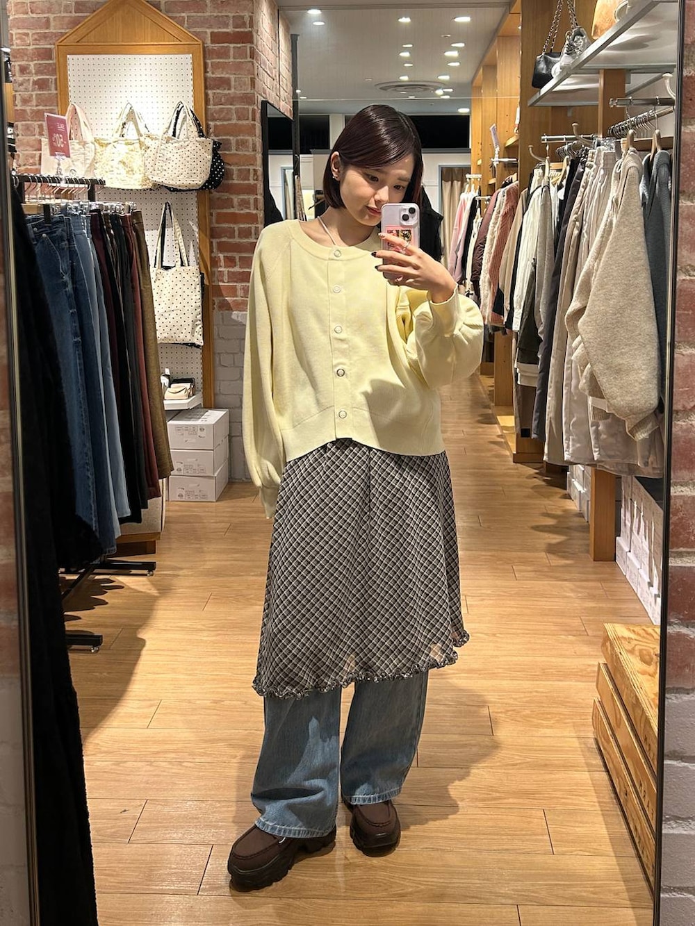 ブルー系のデニムパンツ、ベージュ系のショルダーバッグ、ブラウン系のローファーを着用したレディースの冬コーディネートの5枚目の写真