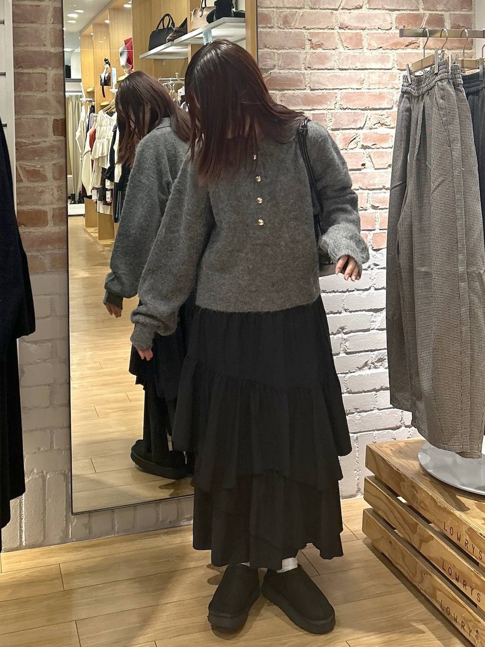 ブラック系のスカート、ブラック系のその他シューズ、グレー系のニット/セーターを着用したレディースの秋コーディネートの2枚目の写真