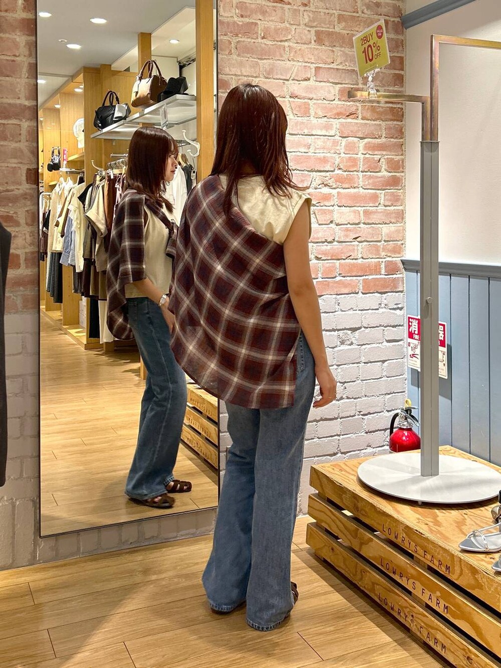 ブラウン系のサンダル、ブルー系のデニムパンツ、レッド系のシャツ/ブラウスを着用したレディースの夏コーディネートの4枚目の写真