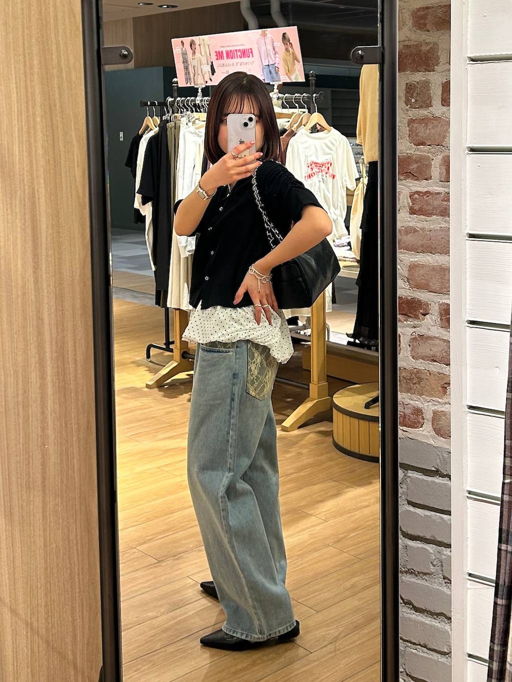 ブルー系のデニムパンツ、ブラック系のショルダーバッグ、ブラック系のサンダルを着用したレディースの春コーディネートの2枚目の写真