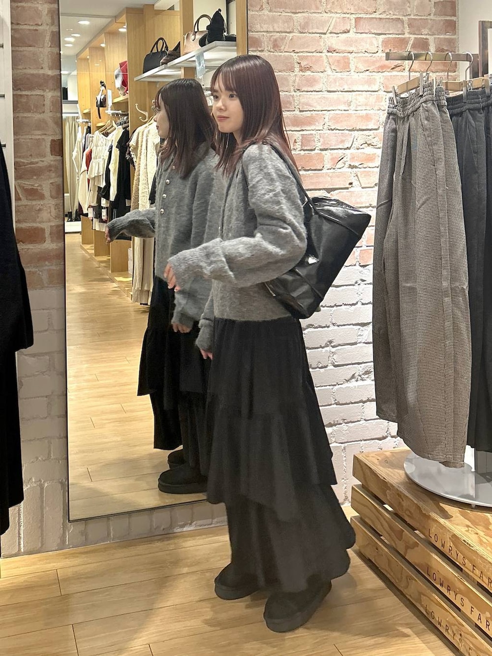 ブラック系のスカート、ブラック系のその他シューズ、グレー系のニット/セーターを着用したレディースの秋コーディネートの3枚目の写真