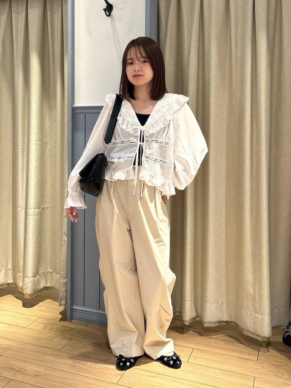 ブラック系のTシャツ/カットソー、ブラック系のショルダーバッグ、ブラック系のバレエシューズを着用したレディースの夏コーディネートの2枚目の写真