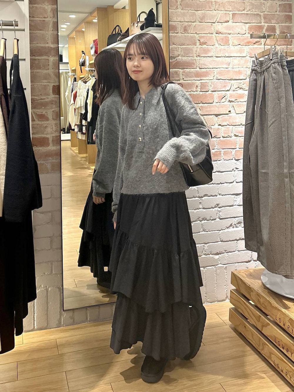 ブラック系のスカート、ブラック系のその他シューズ、グレー系のニット/セーターを着用したレディースの秋コーディネートの5枚目の写真
