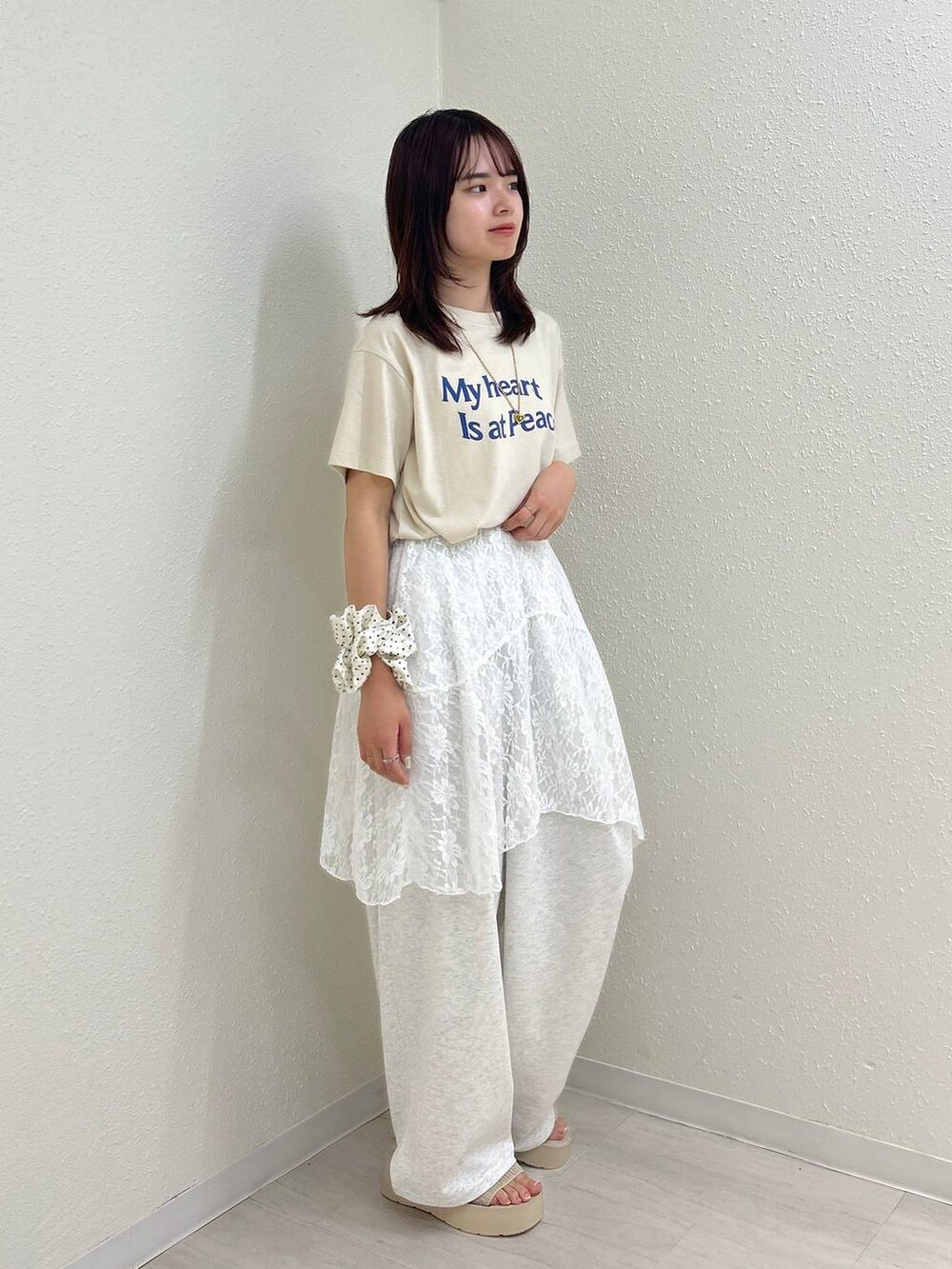ホワイト系のサンダル、グレー系のデニムパンツ、ホワイト系のスカートを着用したレディースの夏コーディネートの4枚目の写真