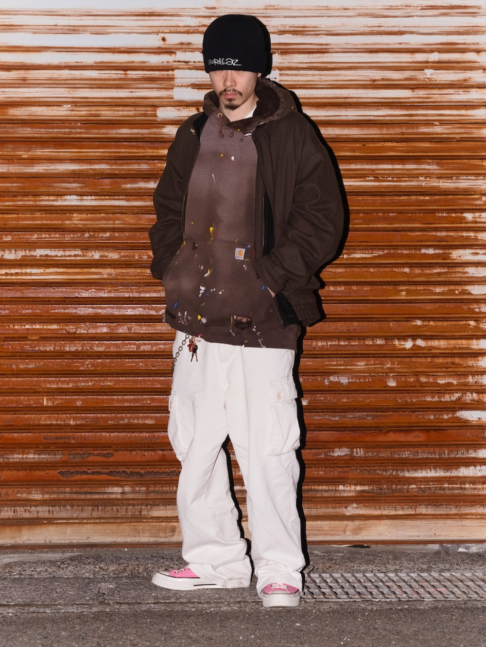 ブラウン系のパーカー、ホワイト系のカーゴパンツ、ピンク系のスニーカーを着用したメンズの春コーディネートの2枚目の写真