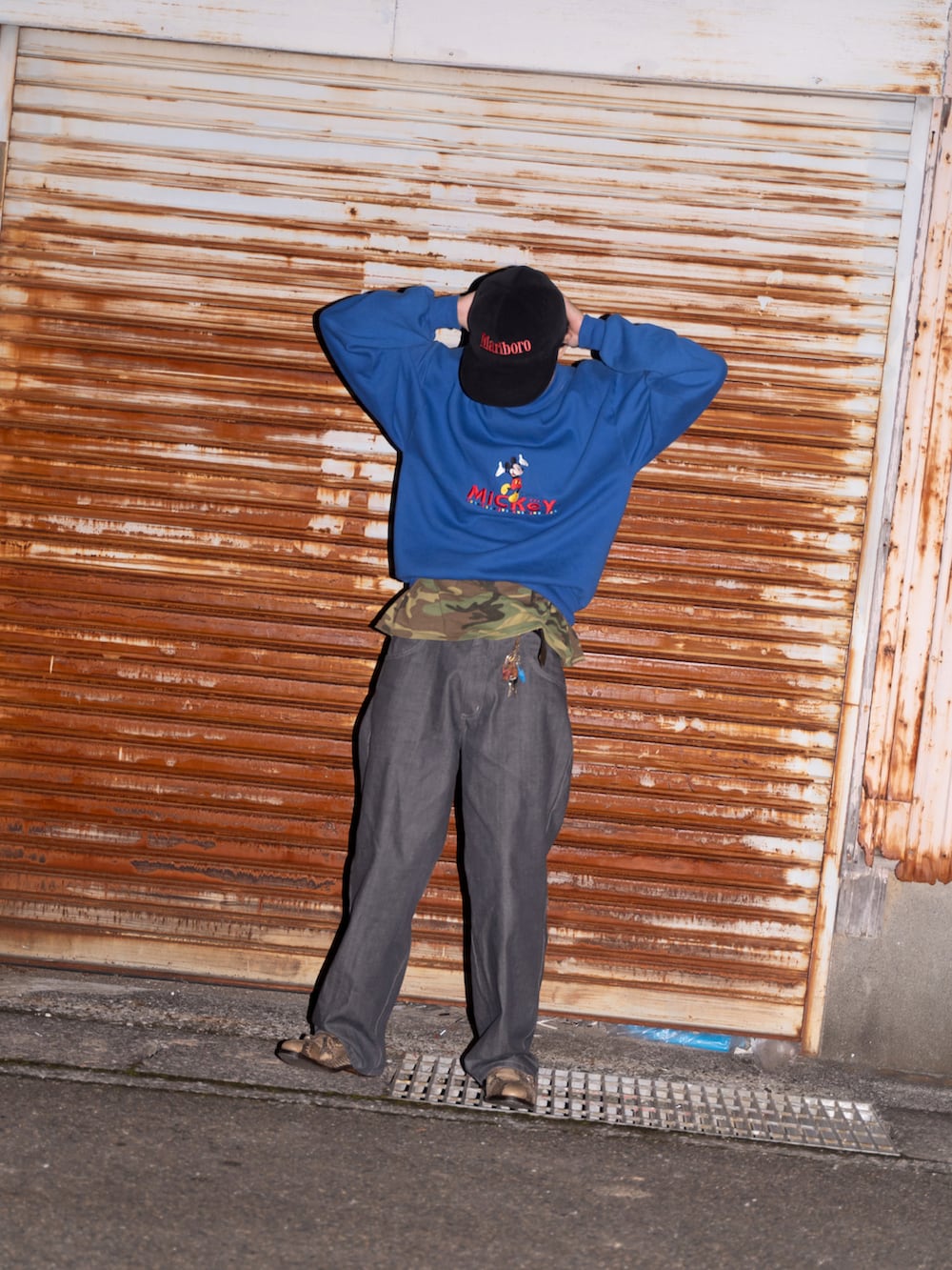 ブルー系のスウェット、ブルー系のデニムパンツ、ベージュ系のドレスシューズを着用したメンズの秋コーディネートの2枚目の写真