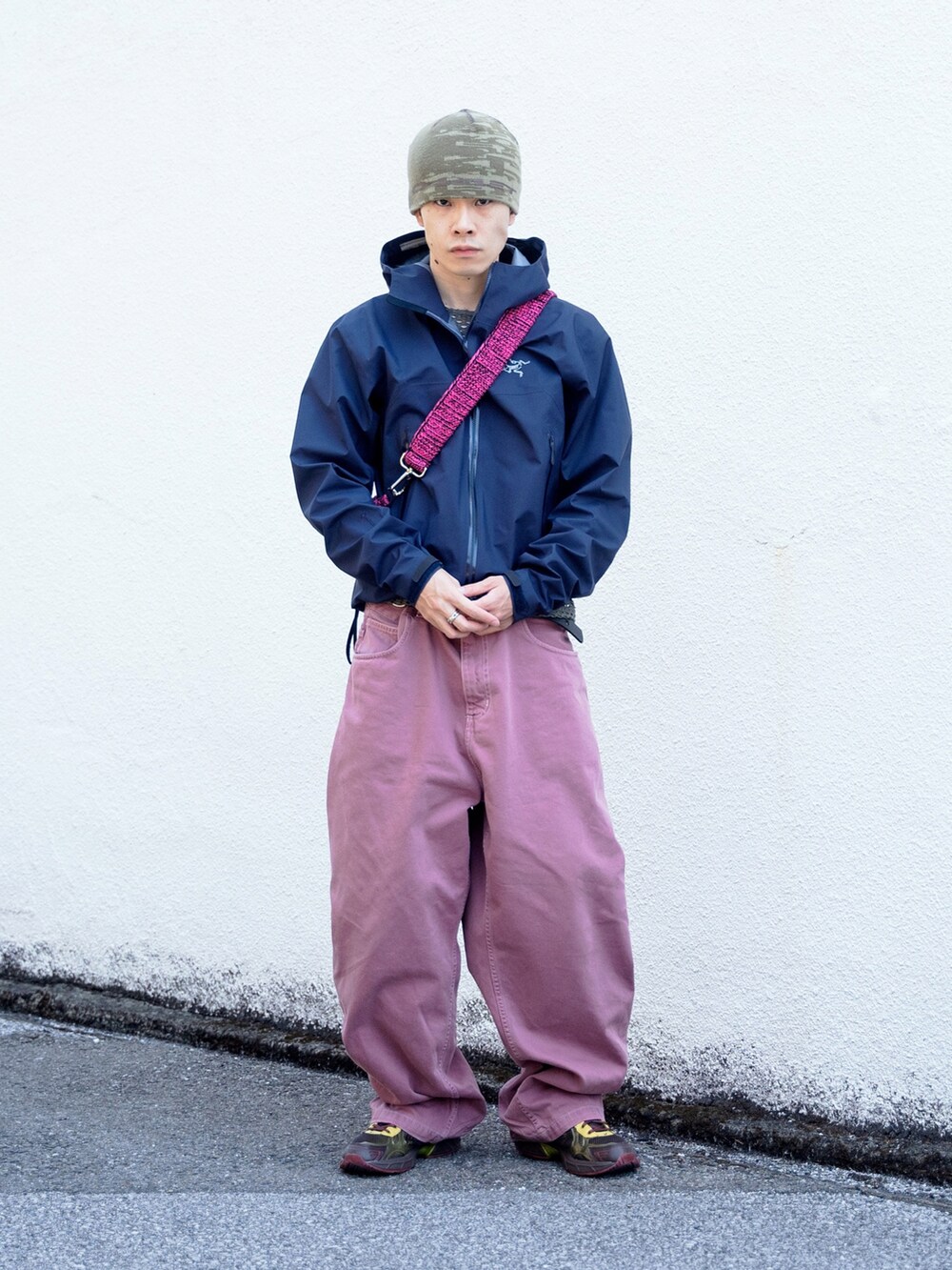 ピンク系のショルダーバッグ、ブルー系のナイロンジャケット、ピンク系のカーゴパンツを着用したメンズの春コーディネートの2枚目の写真