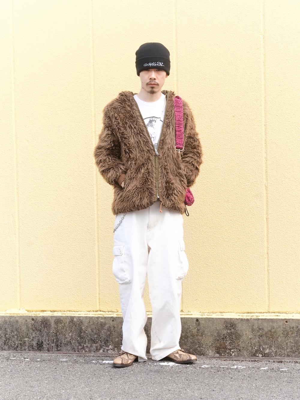 ホワイト系のカーゴパンツ、ベージュ系のドレスシューズ、ブラウン系のミリタリージャケットを着用したメンズの冬コーディネートの2枚目の写真