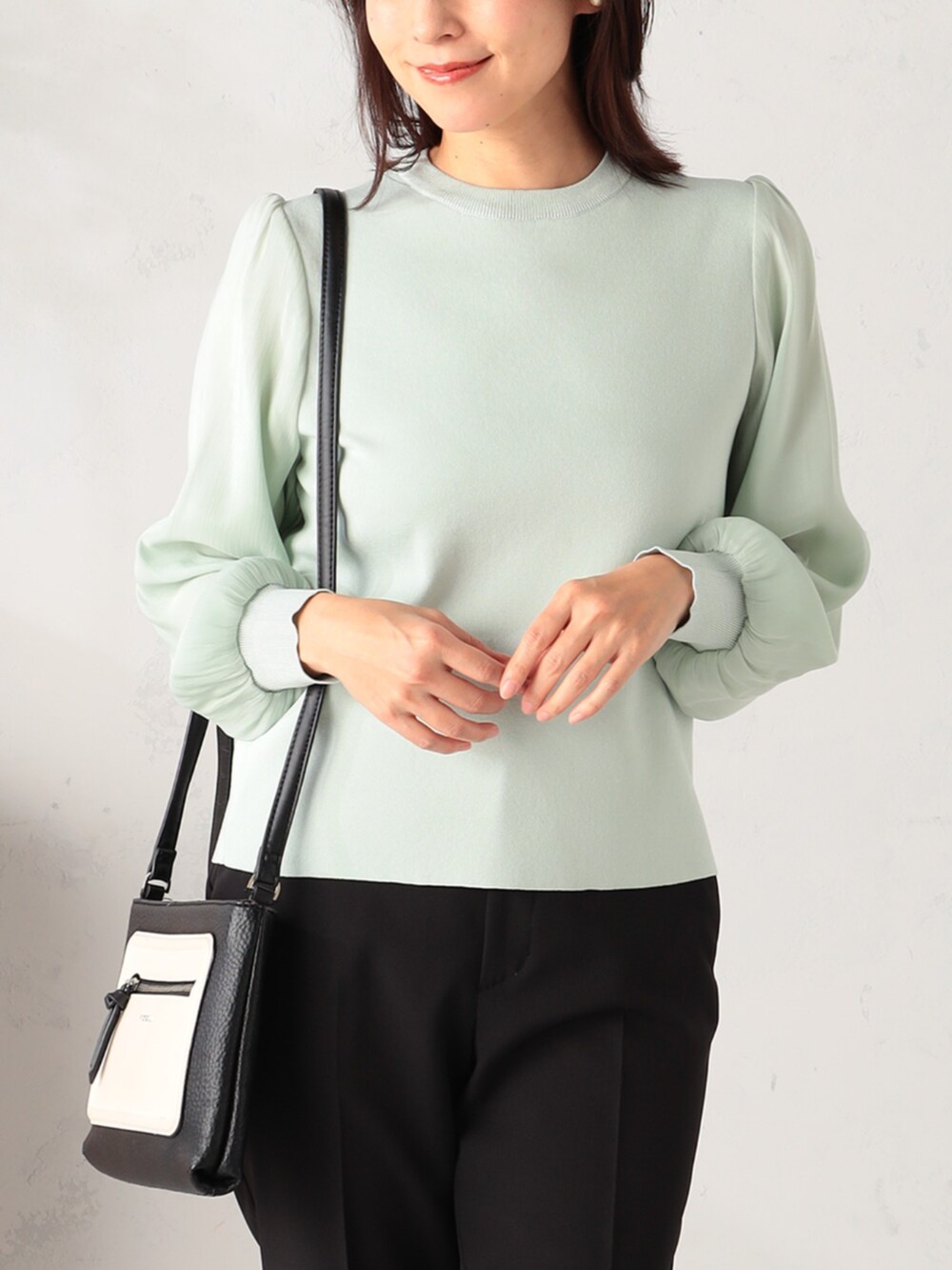 ブラック系のその他パンツ、グリーン系のニット/セーターを着用したレディースの冬コーディネートの2枚目の写真