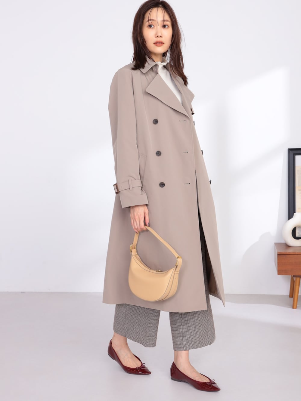 ブラウン系のその他パンツ、ベージュ系のトレンチコート、ベージュ系のTシャツ/カットソーを着用したレディースの冬コーディネートの2枚目の写真