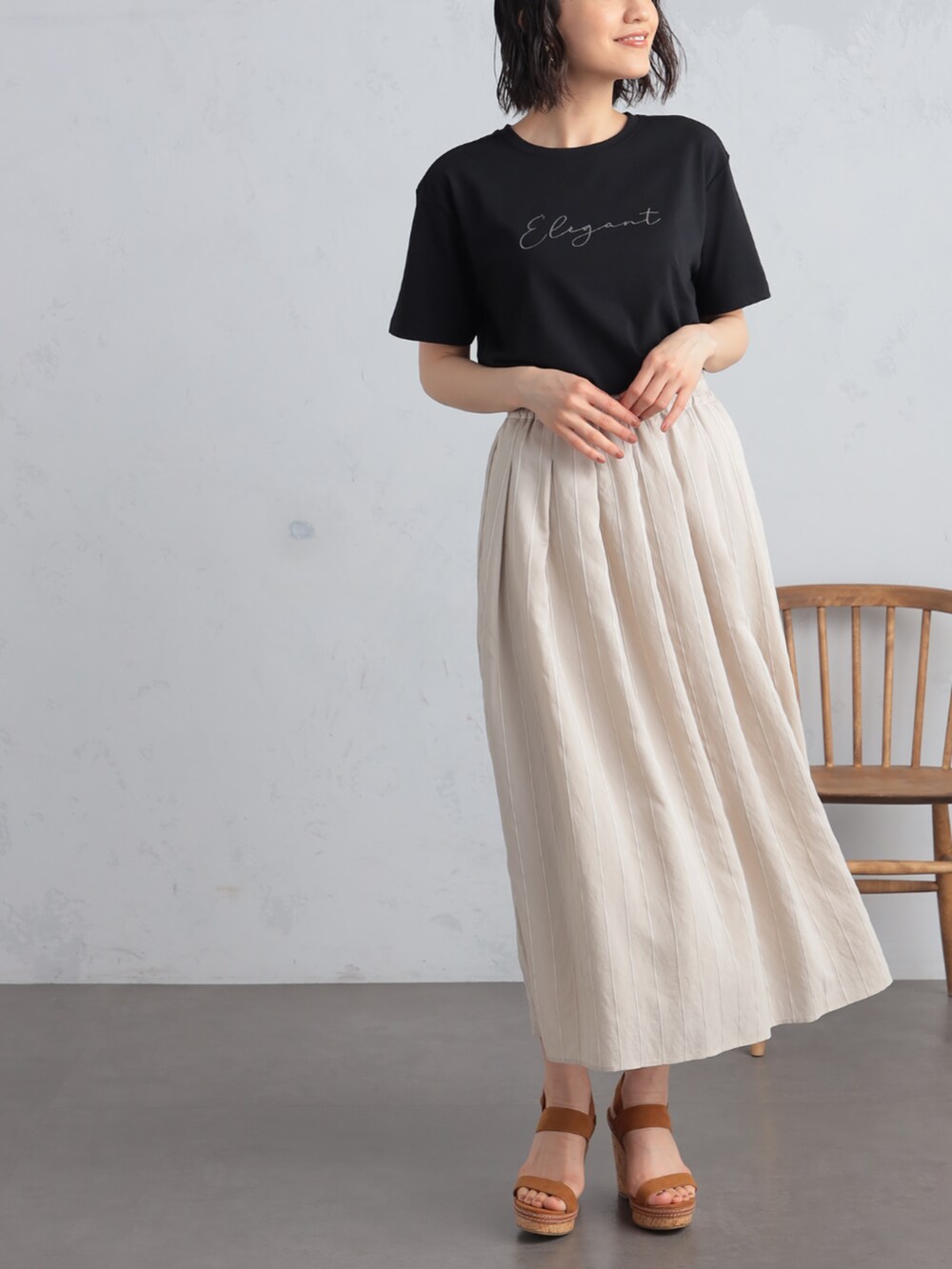 ブラック系のTシャツ/カットソー、ベージュ系のスカート、ベージュ系のパーカーを着用したレディースの夏コーディネートの3枚目の写真