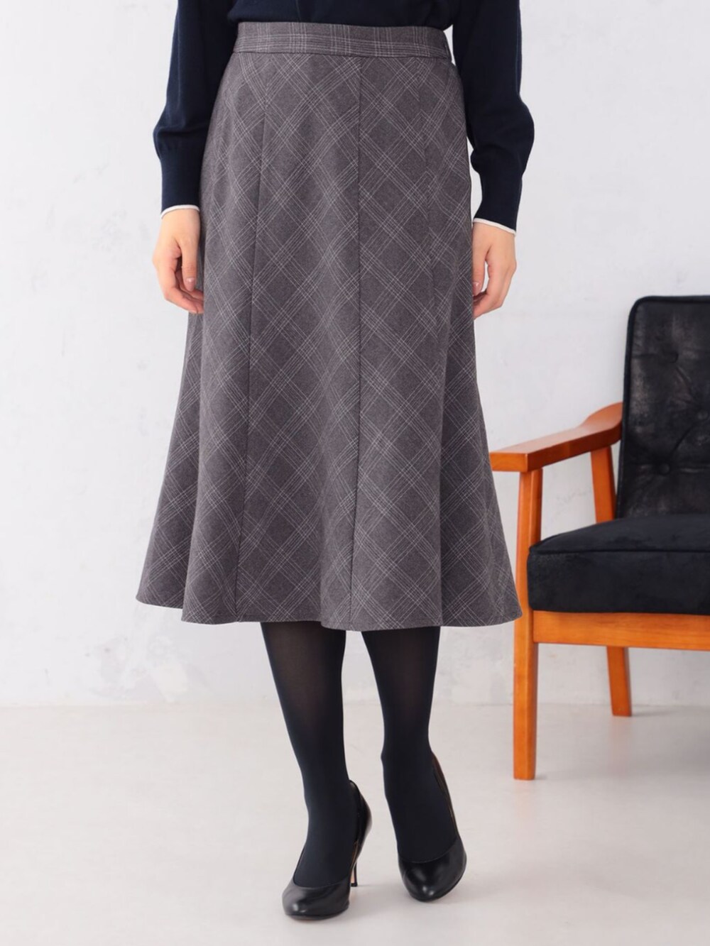 グレー系のスカート、ブルー系のニット/セーターを着用したレディースの冬コーディネートの2枚目の写真