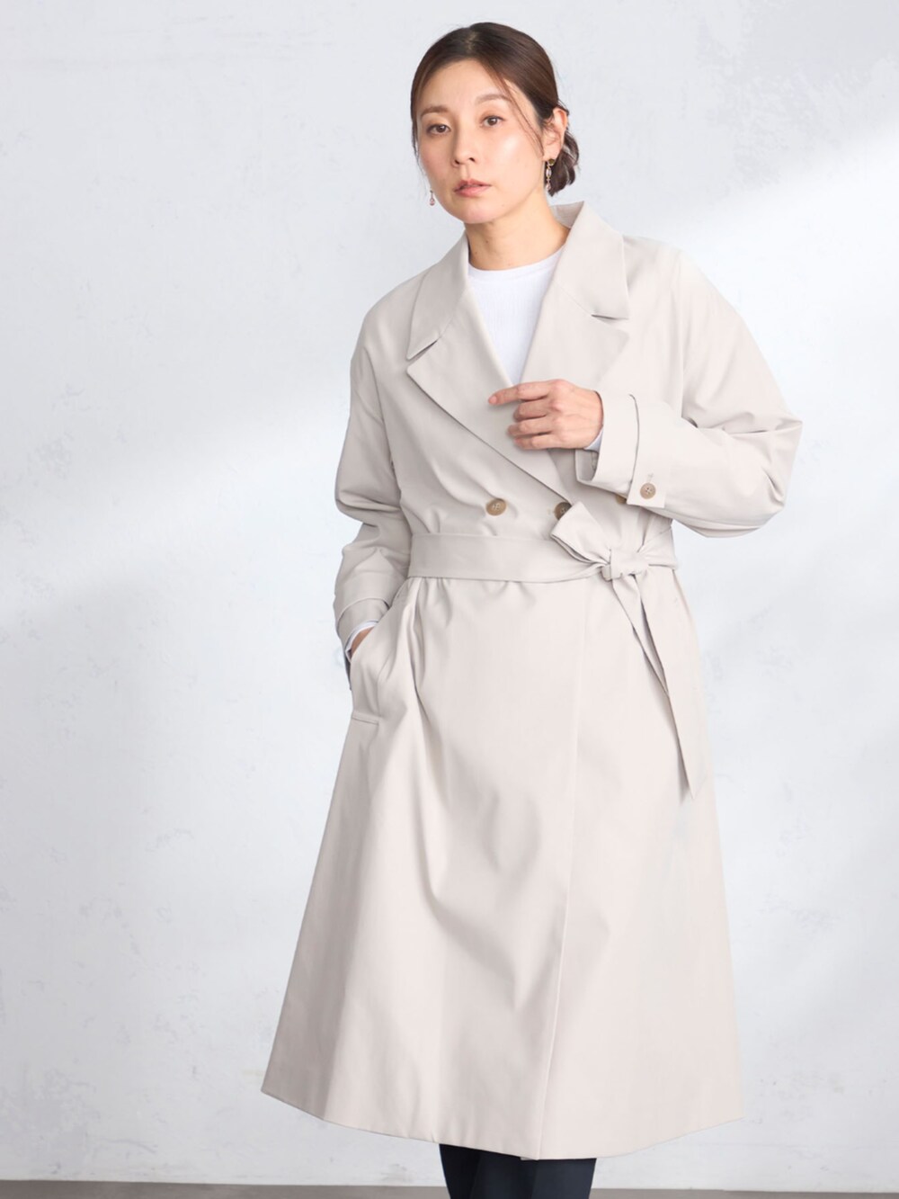 ブルー系のその他パンツ、ベージュ系のトレンチコート、ホワイト系のニット/セーターを着用したレディースの春コーディネートの2枚目の写真