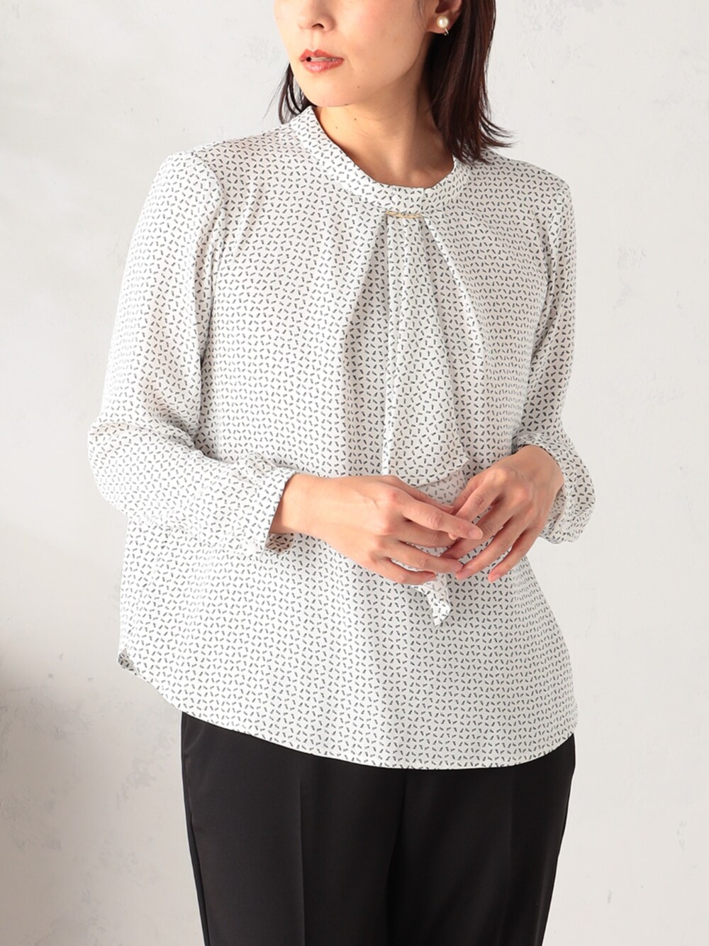 ベージュ系のステンカラーコート、ホワイト系のシャツ/ブラウス、ブラック系のその他パンツを着用したレディースの冬コーディネートの4枚目の写真