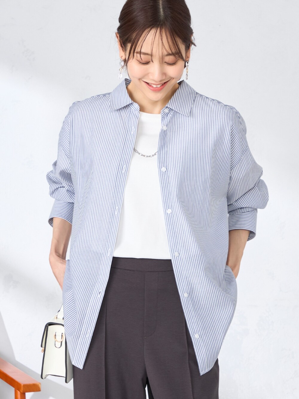 グレー系のその他パンツ、ブルー系のシャツ/ブラウスを着用したレディースの春コーディネートの2枚目の写真