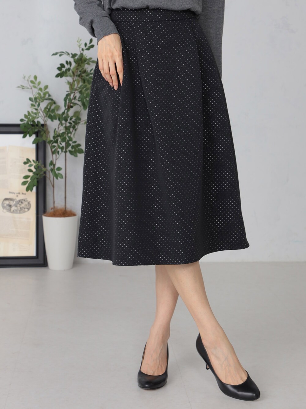 グレー系のニット/セーター、ブラック系のスカートを着用したレディースの秋コーディネートの3枚目の写真