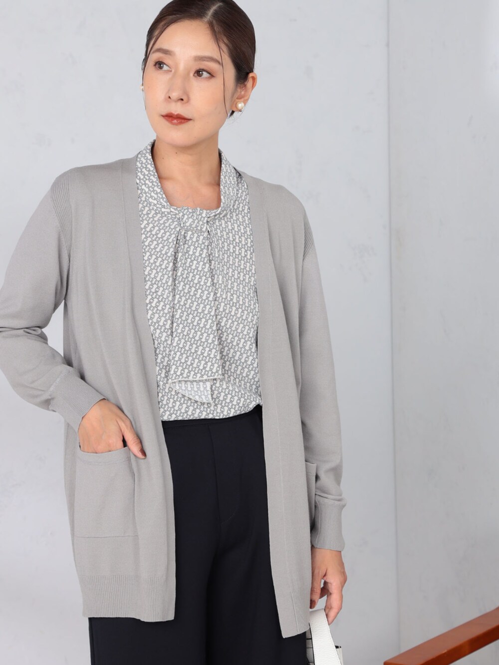 グレー系のシャツ/ブラウス、ブルー系のその他パンツ、グレー系のカーディガン/ボレロを着用したレディースの秋コーディネートの2枚目の写真