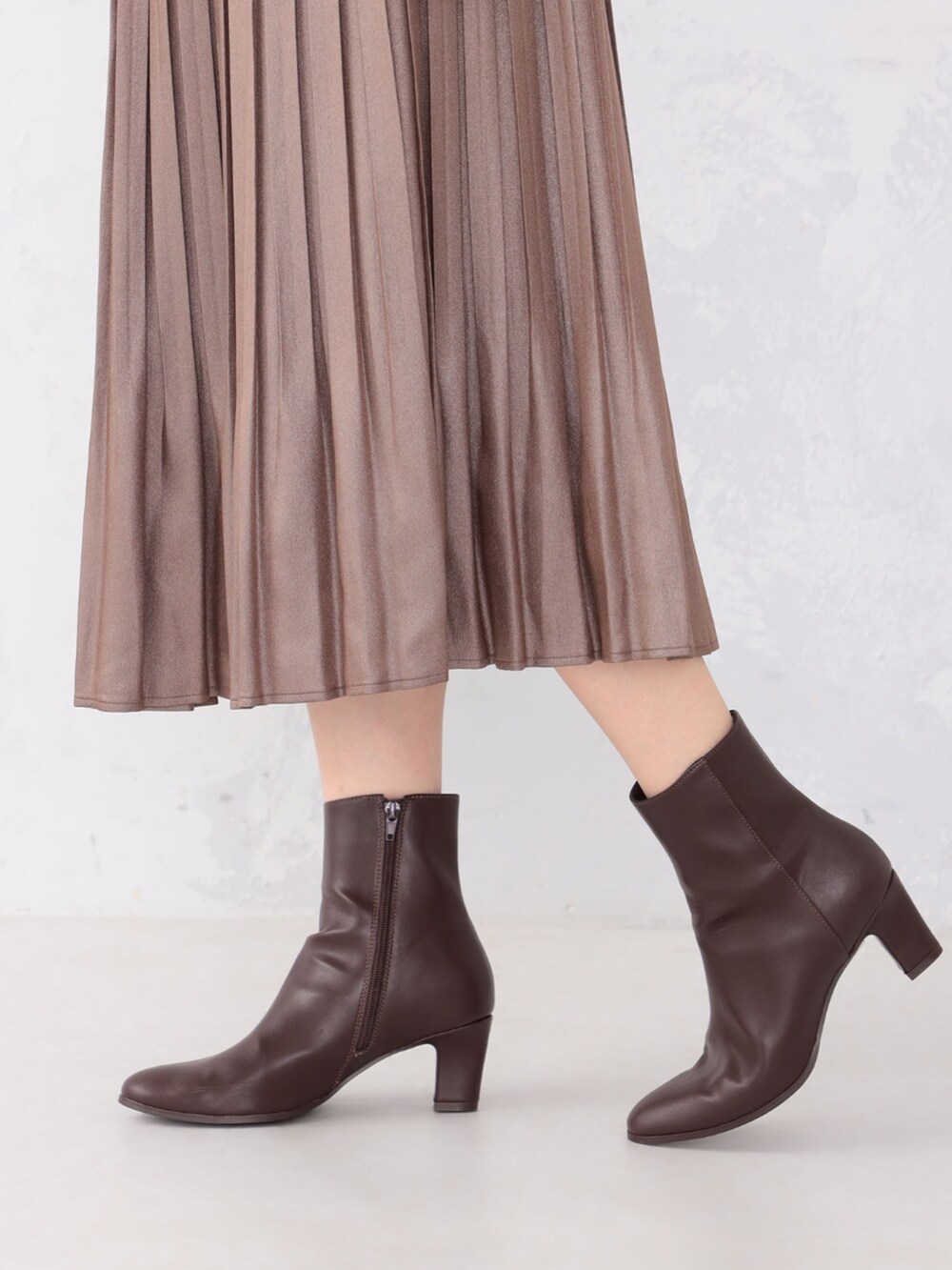 ブラウン系のスカート、グレー系のニット/セーターを着用したレディースの秋コーディネートの4枚目の写真