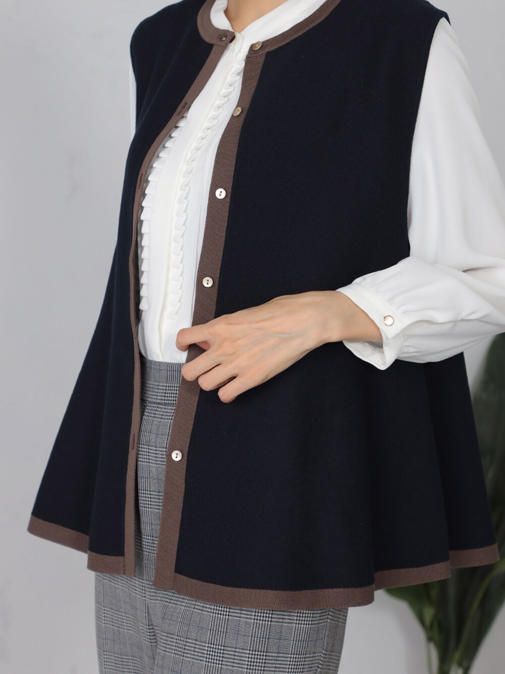 ブルー系のベスト、グレー系のその他パンツ、ホワイト系のシャツ/ブラウスを着用したレディースの秋コーディネートの3枚目の写真