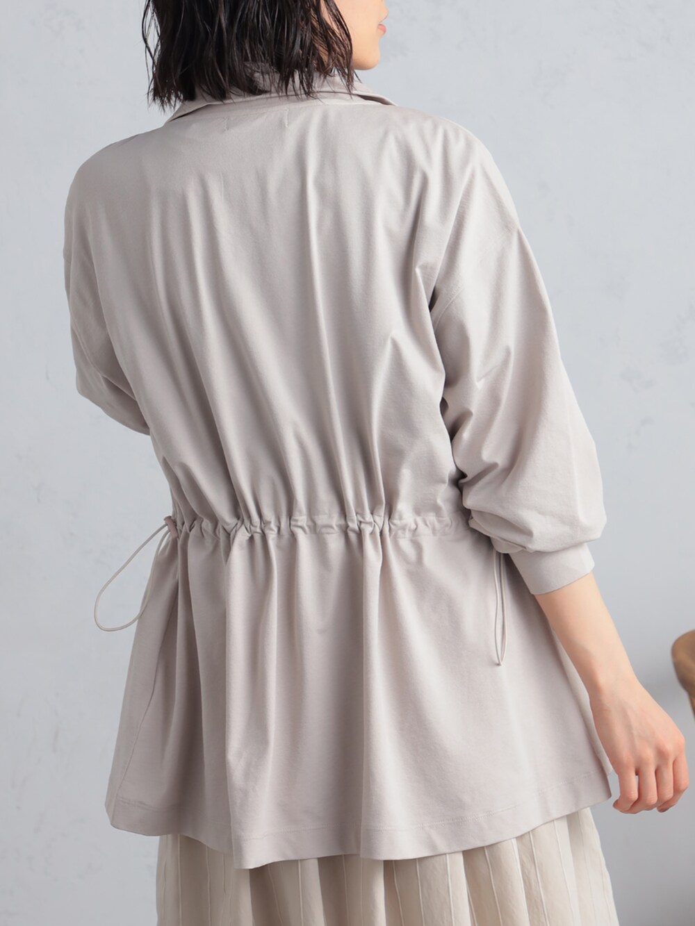 ブラック系のTシャツ/カットソー、ベージュ系のスカート、ベージュ系のパーカーを着用したレディースの夏コーディネートの2枚目の写真