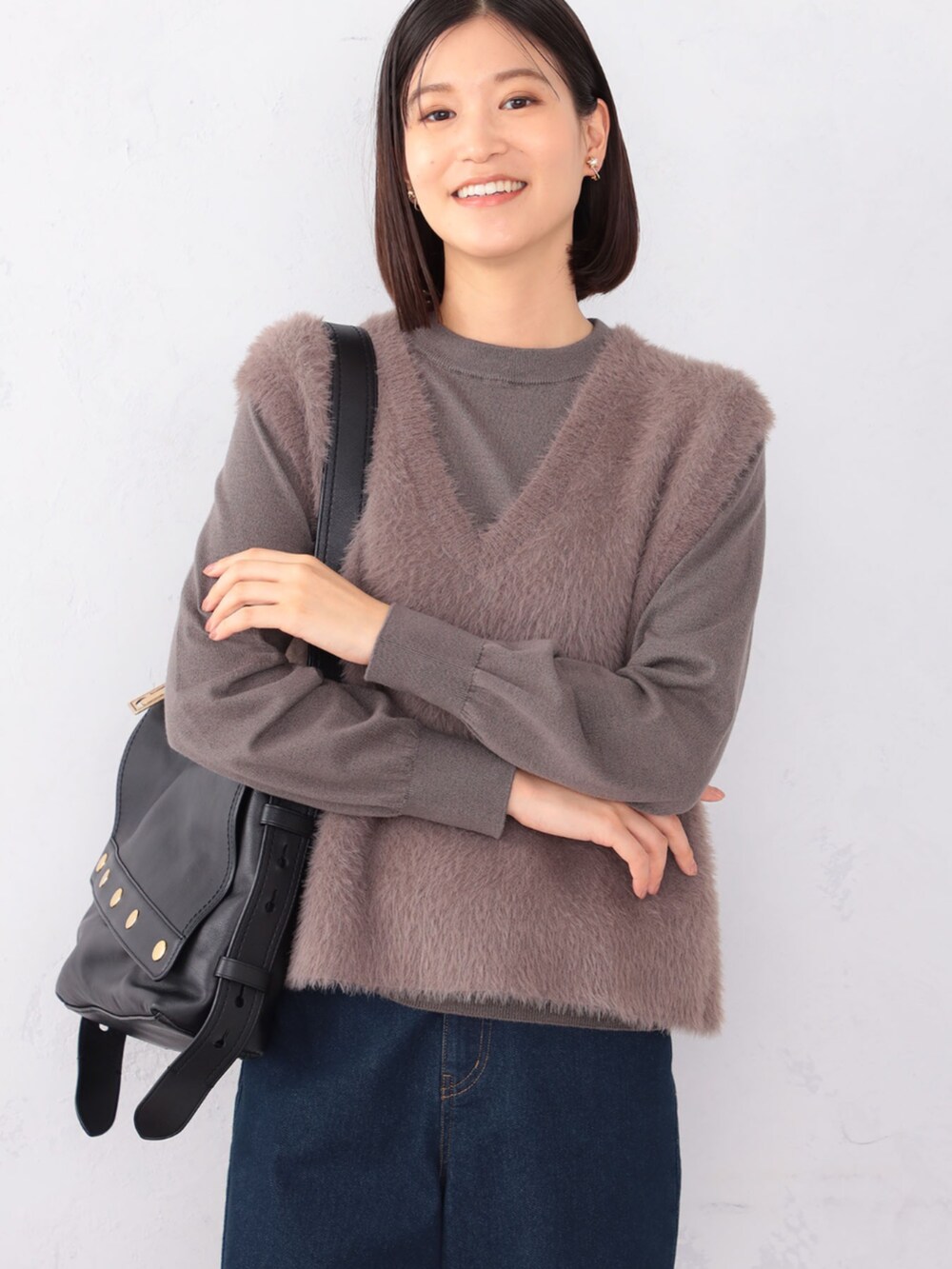 ブルー系のデニムパンツ、ブラウン系のアンサンブルを着用したレディースの秋コーディネートの2枚目の写真