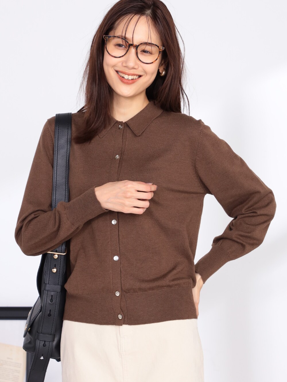 ブラウン系のカーディガン/ボレロ、ベージュ系のスカートを着用したレディースの秋コーディネートの2枚目の写真