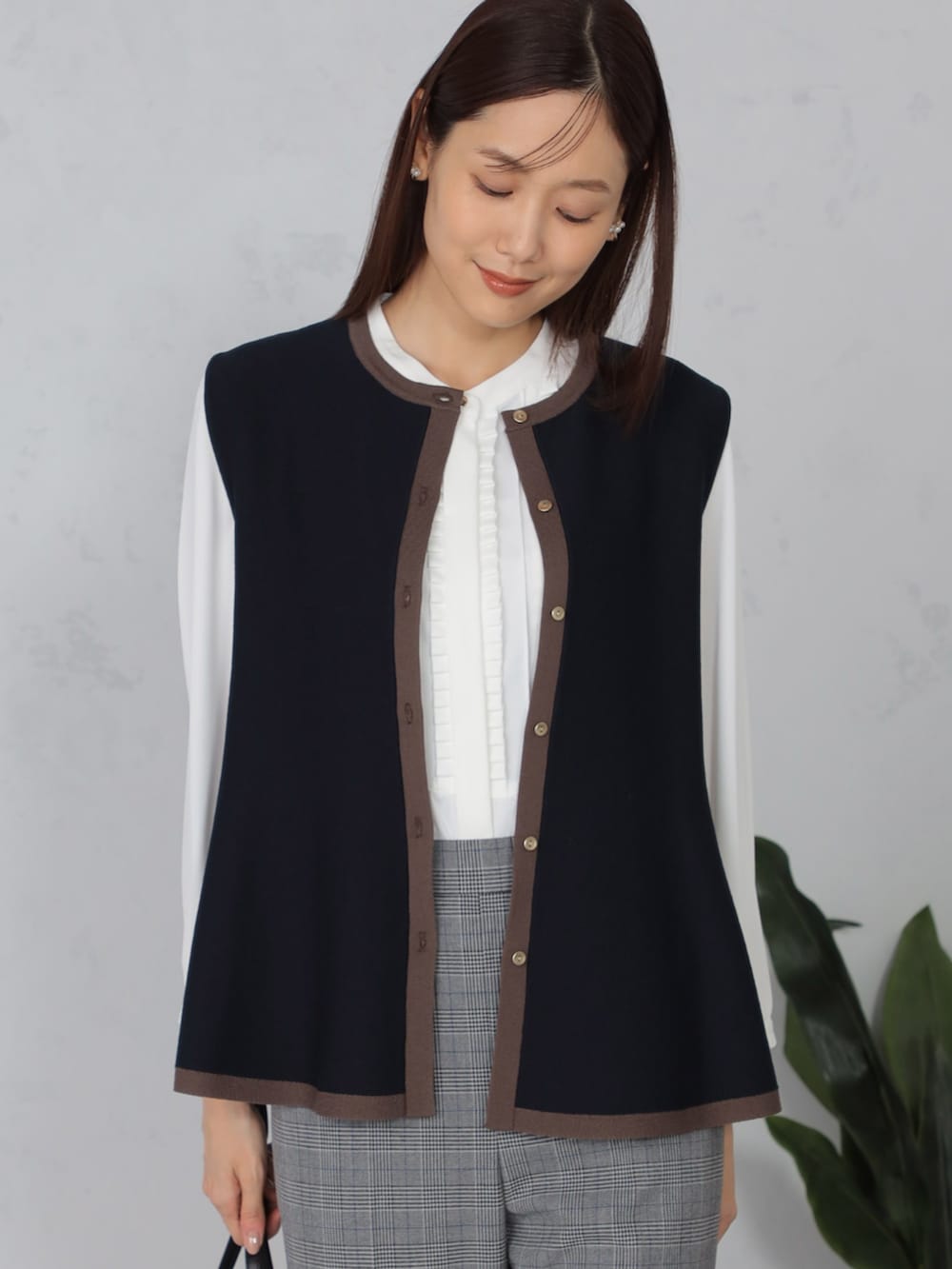 ブルー系のベスト、グレー系のその他パンツ、ホワイト系のシャツ/ブラウスを着用したレディースの秋コーディネートの2枚目の写真