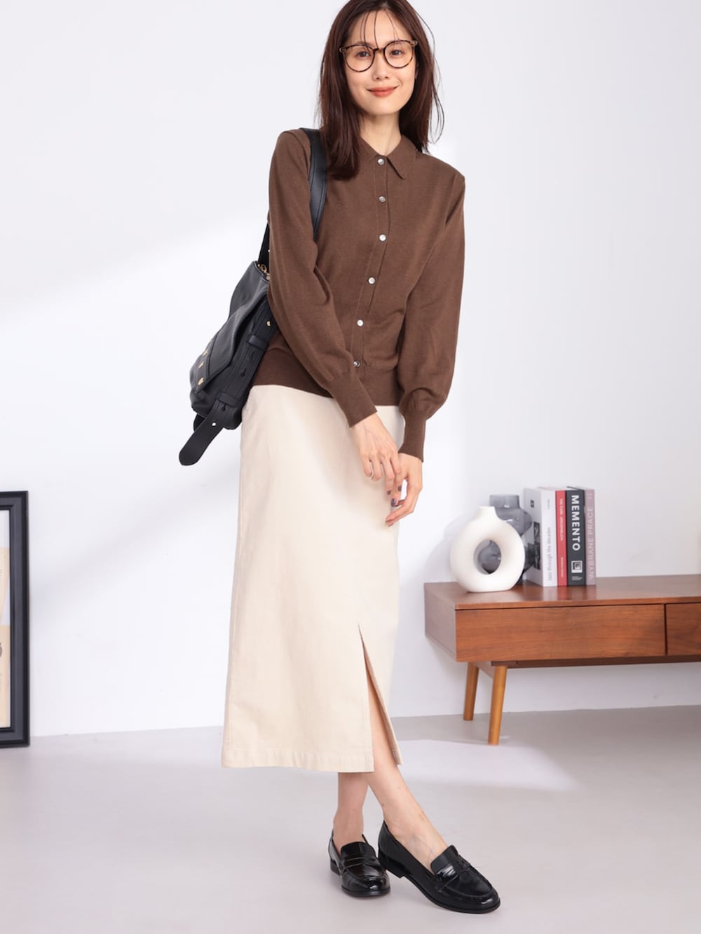 ブラウン系のカーディガン/ボレロ、ベージュ系のスカートを着用したレディースの冬コーディネートの2枚目の写真