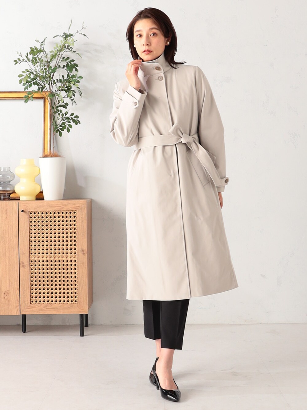 ベージュ系のステンカラーコート、ホワイト系のシャツ/ブラウス、ブラック系のその他パンツを着用したレディースの冬コーディネートの2枚目の写真