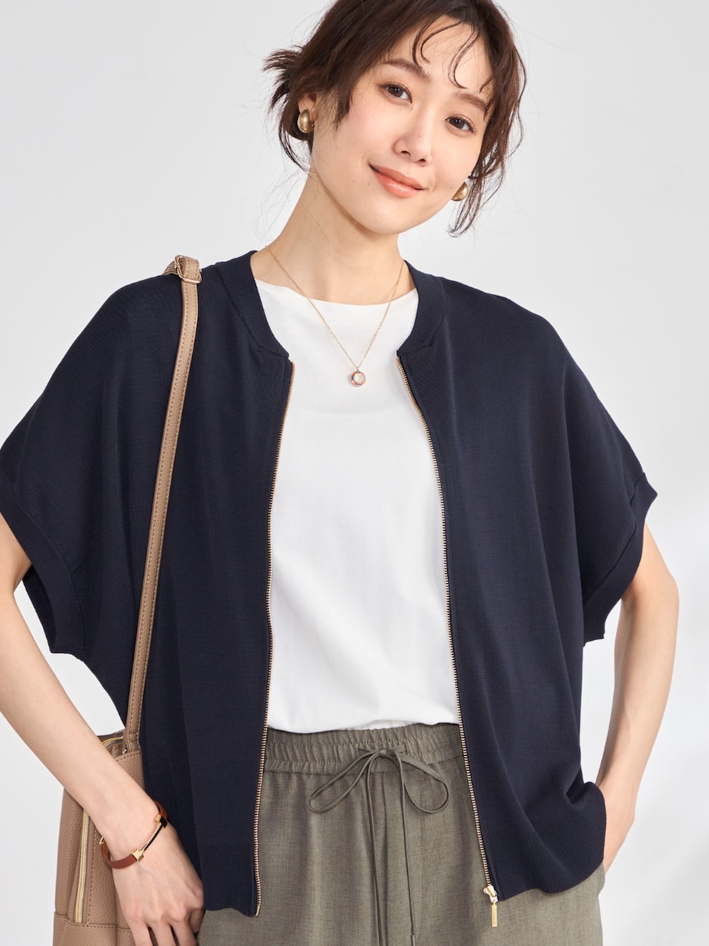 グリーン系のその他パンツ、ブルー系のカーディガン/ボレロ、ホワイト系のTシャツ/カットソーを着用したレディースの春コーディネートの2枚目の写真