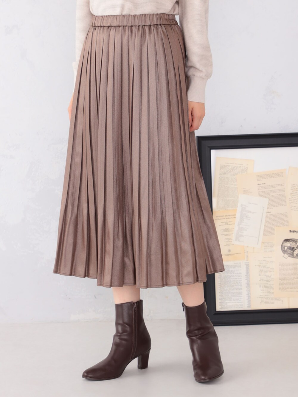 ブラウン系のスカート、グレー系のニット/セーターを着用したレディースの秋コーディネートの3枚目の写真